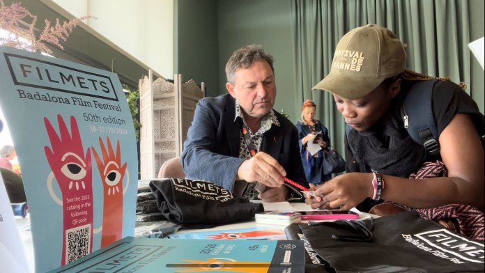 Foto 1 El director artístic de FILMETS, a Canes atenent una cineasta.